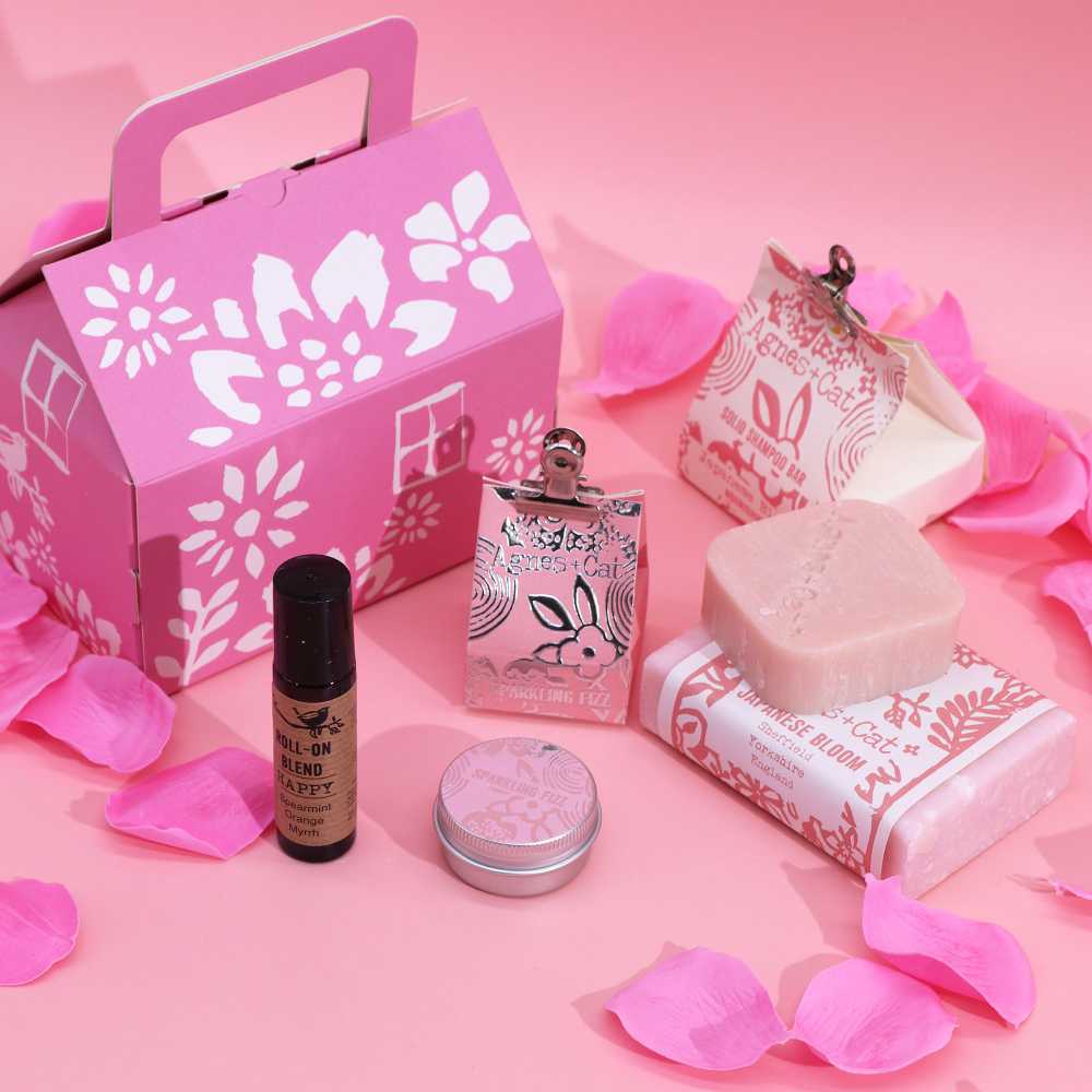 Cosmetic set with pink packaging on a pink background